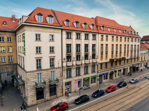 duży budynek z czerwonym dachem na ulicy w obiekcie Hotel Polonia Centrum we Wrocławiu