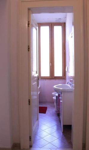 a bathroom with a sink and a toilet and a window at Cilento Casa Vacanza Giuvino in Castelnuovo Cilento