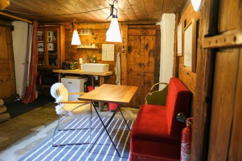 un salon avec une table et un canapé rouge dans l'établissement Refuge Margot, à Chamonix-Mont-Blanc