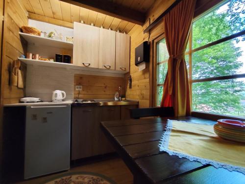 uma cozinha com um frigorífico e uma mesa num quarto em Brvnara Fairy Tale em Cetinje