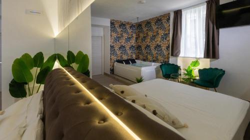 a bedroom with a large white bed and a tub at MAZZINI LUXURY JACUZZY SUITE Catania in Catania