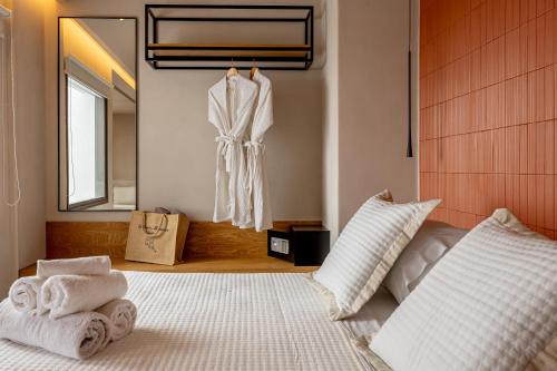 a bedroom with a bed and a robe hanging on the wall at Caldera's Memories in Imerovigli