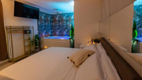 a bedroom with a bed and a tub in a room at MAZZINI LUXURY JACUZZY SUITE Catania in Catania