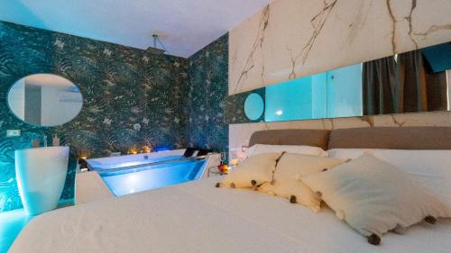 a bedroom with a white bed and blue walls at MAZZINI LUXURY JACUZZY SUITE Catania in Catania