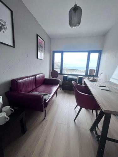 ein Wohnzimmer mit einem Sofa und einem Tisch in der Unterkunft Charmante chambre avec sa salle de bain, vue mer. in Le Conquet