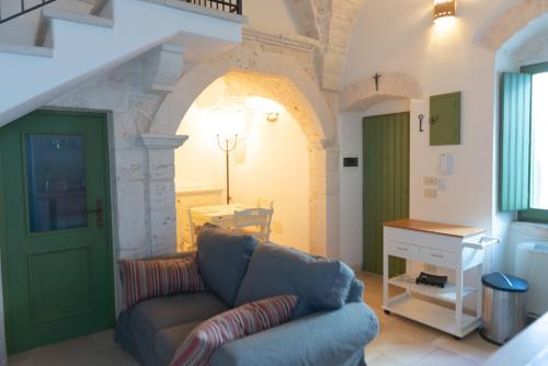 sala de estar con sofá y puerta verde en Casa Sorrentino, en Cisternino