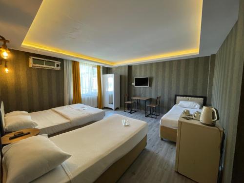 um quarto de hotel com duas camas e uma mesa em deperlas em Atakum