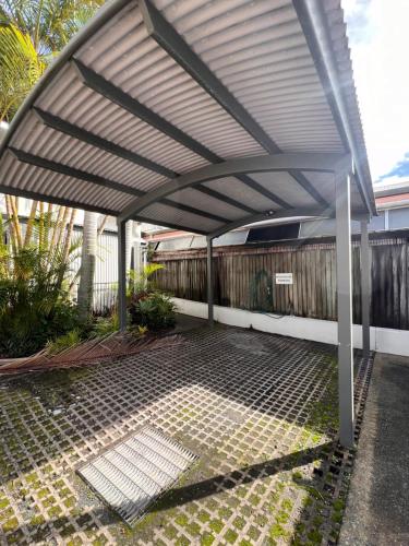 awning over a patio in front of a fence at Sophie's Place ReLaunch - Luxury Penthouse in Byron Bay