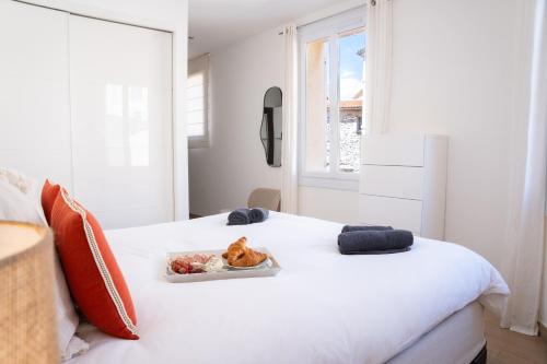 uma cama branca com um prato de comida em Port de Saint-Tropez em Saint-Tropez