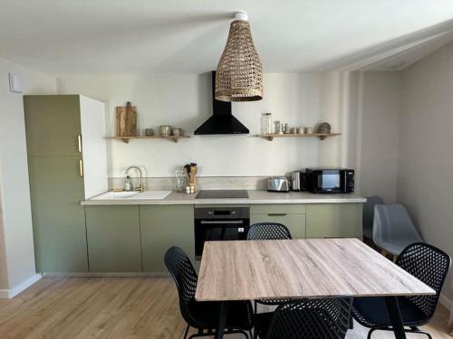 a kitchen with a table and chairs in a kitchen at Appartement duplex 4-6 personnes in Cerizay