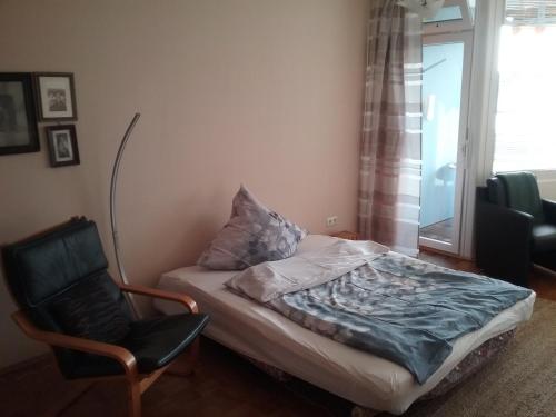 Un dormitorio con una cama y una silla y una ventana. en Europaplatz, en Aachen