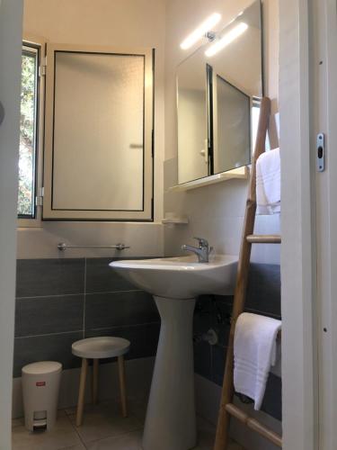 baño con lavabo, espejo y taburete en TRILOCALE 2 SUL MARE, en Peschici