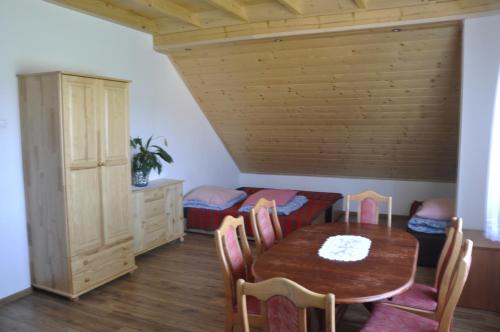 - une salle à manger avec une table et des chaises dans l'établissement Pokoje nad jeziorem - U Joanny, à Bartkowa-Posadowa