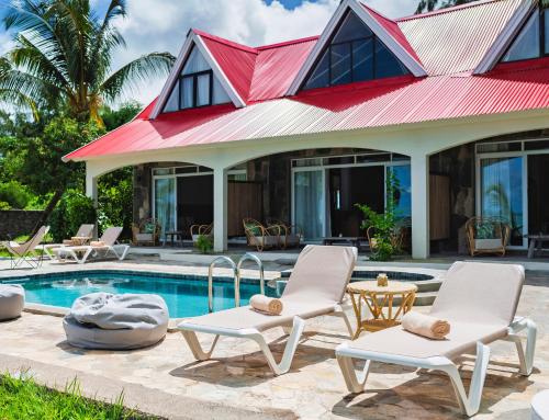 a villa with a swimming pool and two chairs and a house at C Rodrigues Mourouk in Rodrigues Island