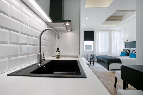 a kitchen with a sink and a living room at Angel Main Square Center Zagreb in Zagreb