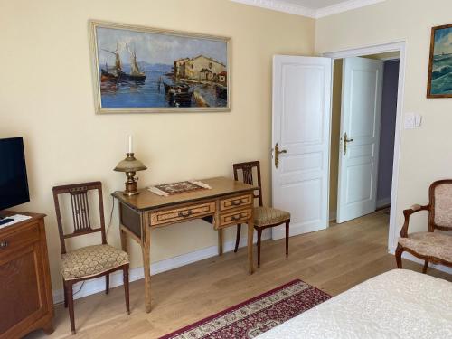 a room with a desk and chairs and a bed at Logis Vélès in Aubin