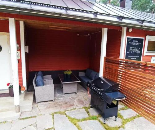 a patio with a grill and some chairs and a table at Wanha Koulu Tahko Onnela, 4mh, Palju, Sauna, Tupakeittiö, Wifi, Liikuntasali, RinteetSpaRavintola 6km, Lemmikit OK, Edukas in Reittiö