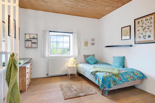 um quarto com uma cama, uma secretária e uma janela em Præstøgaard em Praesto