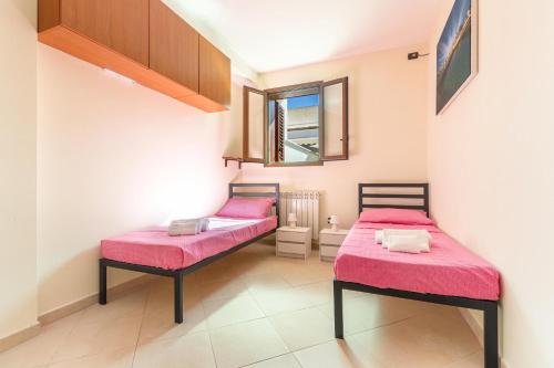two beds in a room with pink sheets and a mirror at Casa Anja by BarbarHouse in Marina di Leuca