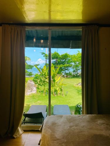 a bedroom with a bed and a window with a view at Coconut Suite in General Luna