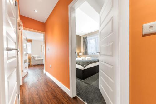 a bedroom with orange walls and a bed in a room at Abbey Apartments Modern ApartHotel for Tourists & Professionals in Barrow in Furness