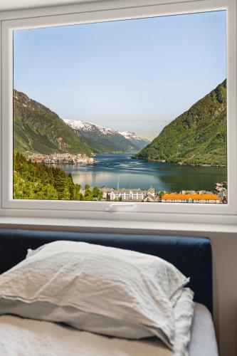 a window with a view of a lake and mountains at Odda Atmosphere in Odda