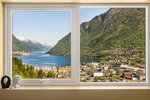 a window with a view of a city and mountains at Odda Atmosphere in Odda