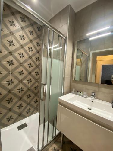 a bathroom with a shower and a sink and a mirror at Logis Vélès in Aubin