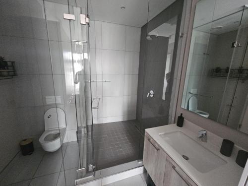 ein Badezimmer mit Dusche, Toilette und Waschbecken in der Unterkunft Capital Trilogy Apartments in Pretoria