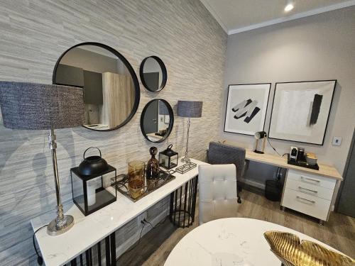 Zimmer mit einem Schreibtisch und einem Spiegel an der Wand in der Unterkunft Capital Trilogy Apartments in Pretoria