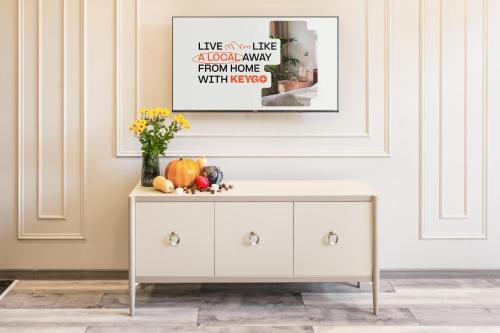 a white dresser with a vase of flowers on it at Apartment KeyGo #0010 next to St Sarkis Church in Yerevan