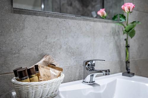a bathroom sink with a basket next to a faucet at La Corte di Ripoli in Bagno a Ripoli