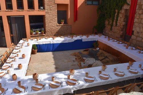 un groupe de tables avec des chaises dans une cour dans l'établissement Castillo de Grisel, à Grisel