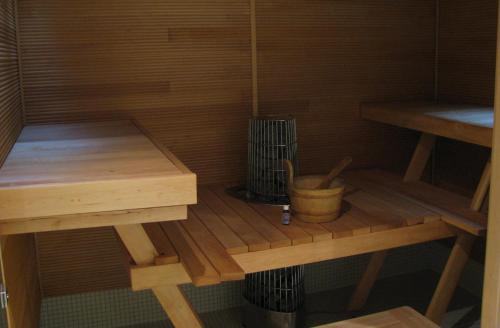 una sauna con 2 mesas de madera y un cubo en Large Family Apartment UNELMA - Tahko, Palju, BBQ, Sauna, WiFI, PetsOK, Budget, Wanha Koulu Tahkovuori en Reittiö