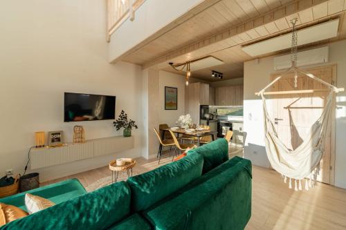 sala de estar con sofá verde y mesa en Beskid Sielski - klimatyczne domki w Lipowej z widokiem na góry i sauną - Dream Apart, en Żywiec