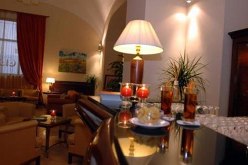 a living room with a table with a lamp at Le Cheminée Business Hotel Napoli in Naples