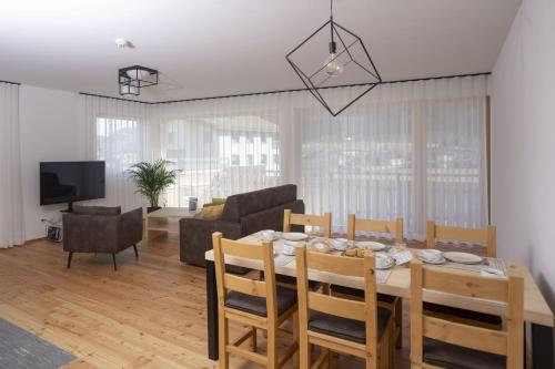 a dining room and living room with a table and chairs at Chasa Helvetia Duai in Müstair
