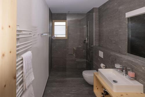 a bathroom with a sink and a toilet at Chasa Helvetia Duai in Müstair