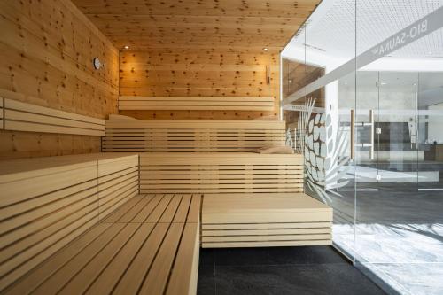 a sauna with wooden floors and a glass wall at Chasa Helvetia Duai in Müstair