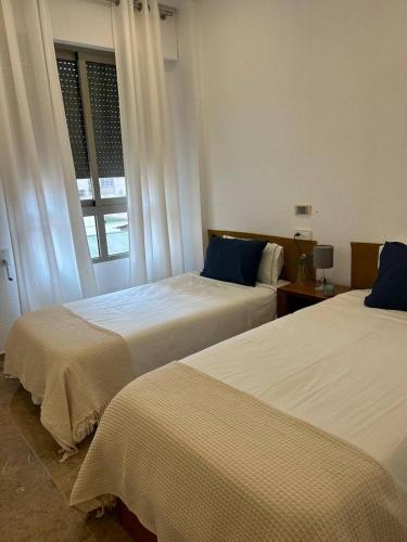 sypialnia z 2 łóżkami i oknem w obiekcie Apartamento REGIDOR w mieście Cartagena