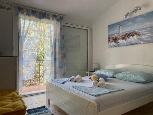a bedroom with a bed with towels and a window at Villa Terra Nostra Hvar in Hvar