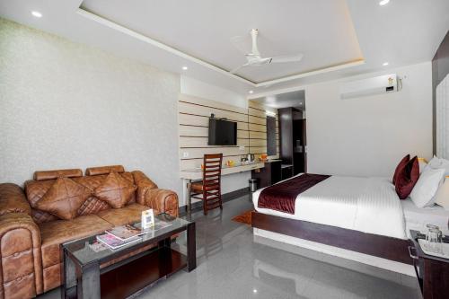 a hotel room with a bed and a couch at Aliza Inn And Suites By SRS Hotels in Dharamshala