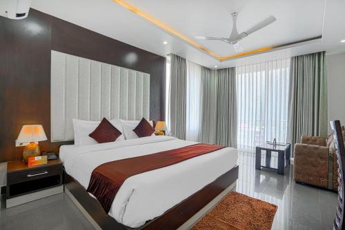 a bedroom with a large bed and a large window at Aliza Inn And Suites By SRS Hotels in Dharamshala