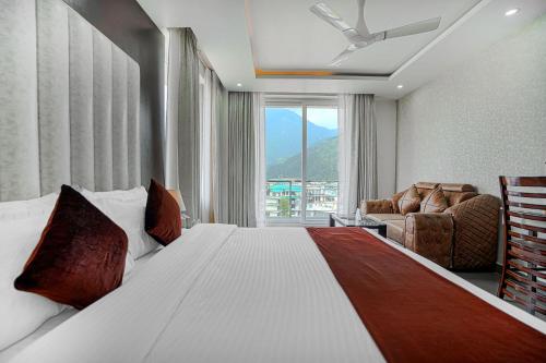 a bedroom with a bed and a chair and a window at Aliza Inn And Suites By SRS Hotels in Dharamshala