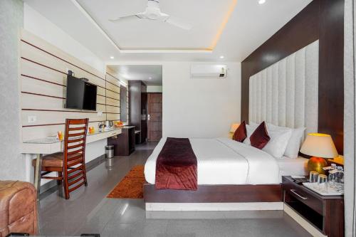 a bedroom with a bed and a desk and a kitchen at Aliza Inn And Suites By SRS Hotels in Dharamshala