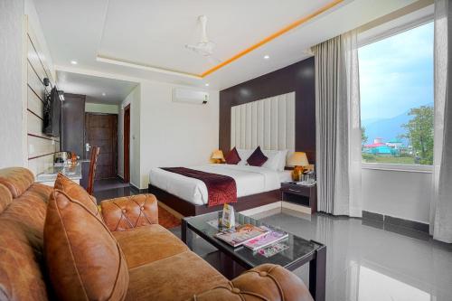 a hotel room with a bed and a couch at Aliza Inn And Suites By SRS Hotels in Dharamshala
