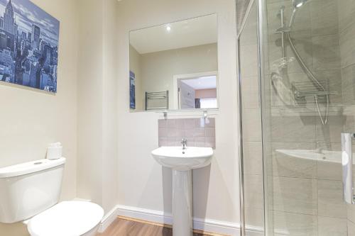 a bathroom with a toilet and a sink and a shower at Abbey Apartments Modern ApartHotel for Tourists & Professionals in Barrow in Furness