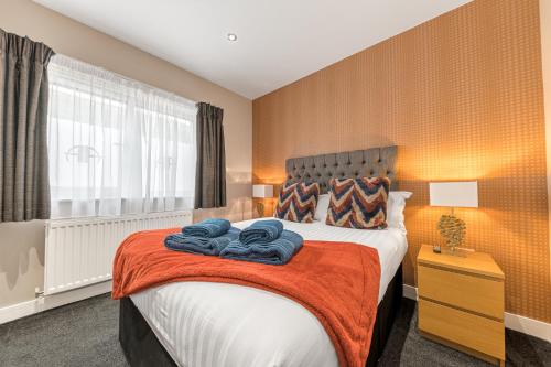 a bedroom with a bed with towels on it at Abbey Apartments Modern ApartHotel for Tourists & Professionals in Barrow in Furness