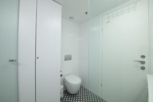 bagno bianco con servizi igienici e doccia di סיסייד אילת חדר עם נוף לים - Seaside Eilat Room With Sea View a Eilat
