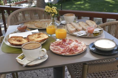 a table topped with plates of food and cups of coffee at Hotel El Rosal de Cudillero in Cudillero
